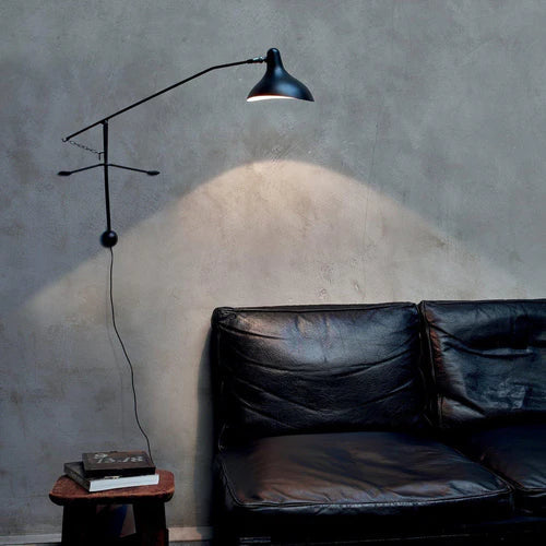 DCW Editions Mantis plug-in wall light BS2 above black leather sofa
