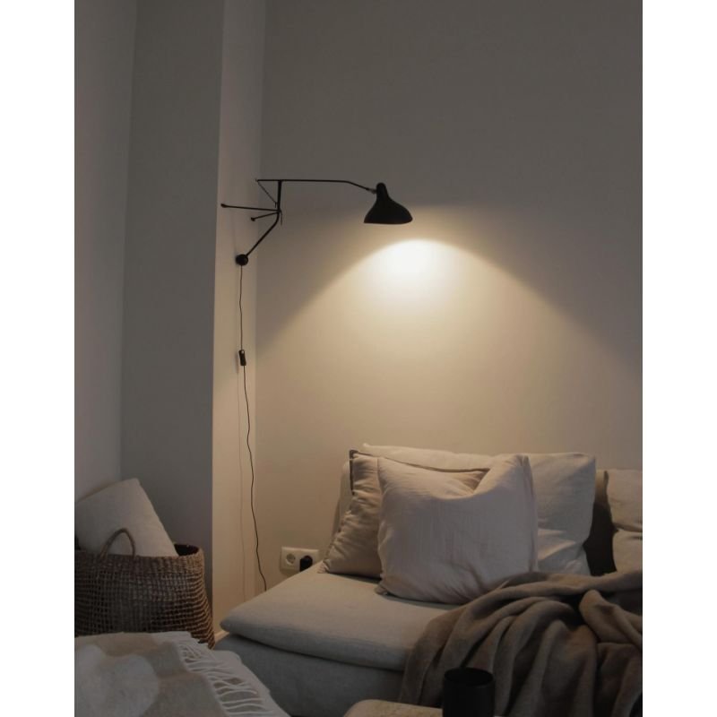 DCW Editions Mantis plug-in wall light BS2 above sofa with cushions and blanket