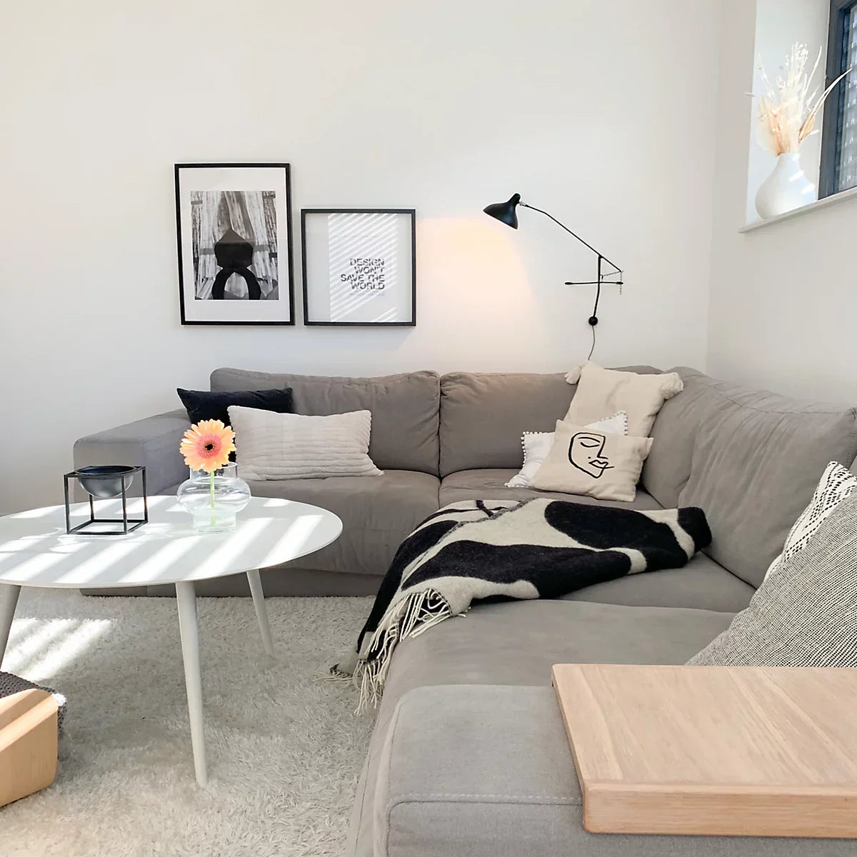 DCW Editions Mantis plug-in wall light BS2 above grey sofa with a white round coffee table