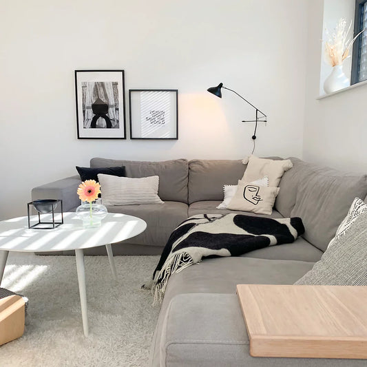 DCW Editions Mantis plug-in wall light BS2 above grey sofa with a white round coffee table