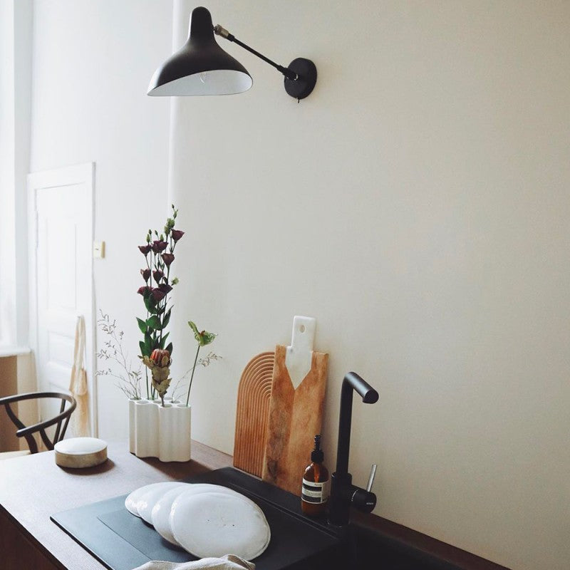 DCW Editions Mantis wall light standard BS5 with thumbswitch over galley kitchen with white plates and black tap