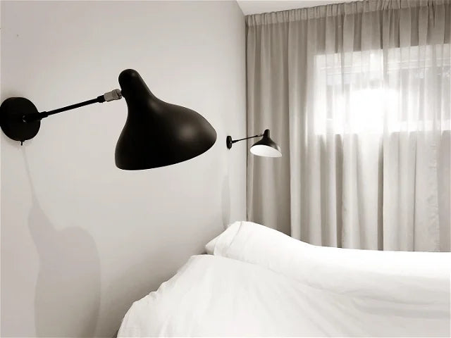 DCW Editions Mantis wall light standard BS5 with thumbswitch on either side of a white bed with curtains in the room