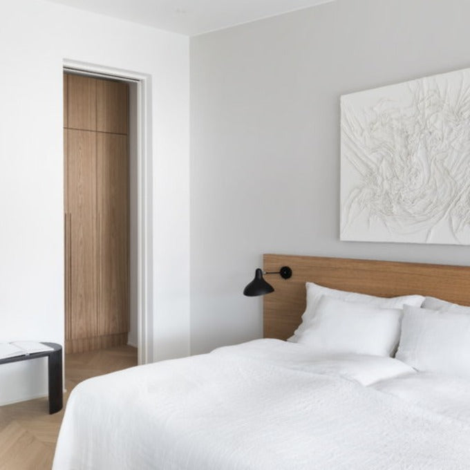DCW Editions Mantis wall light mini BS5 on wooden headboard next to a white bed 