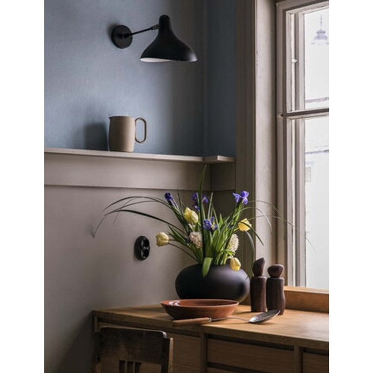 DCW Editions Mantis wall light mini in corner of kitchen with wooden table by a window with a vase of flowers