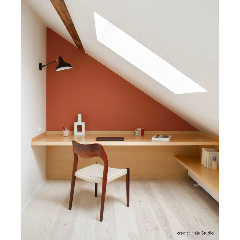 DCW Editions Mantis wall light standard BS5 with thumbswitch next to desk in a corner of a sloped room with an orange wall