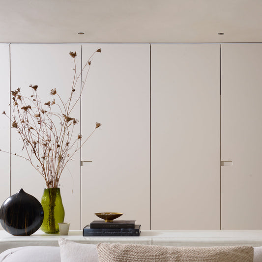 Modern interior with neutral-colored cabinets, a vase with dried flowers, and decorative items.