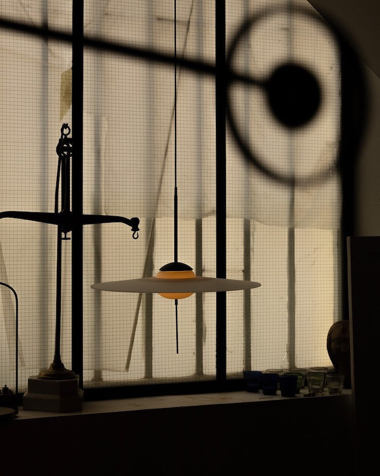 DCW Editions Mono pendant lit with machines in the background