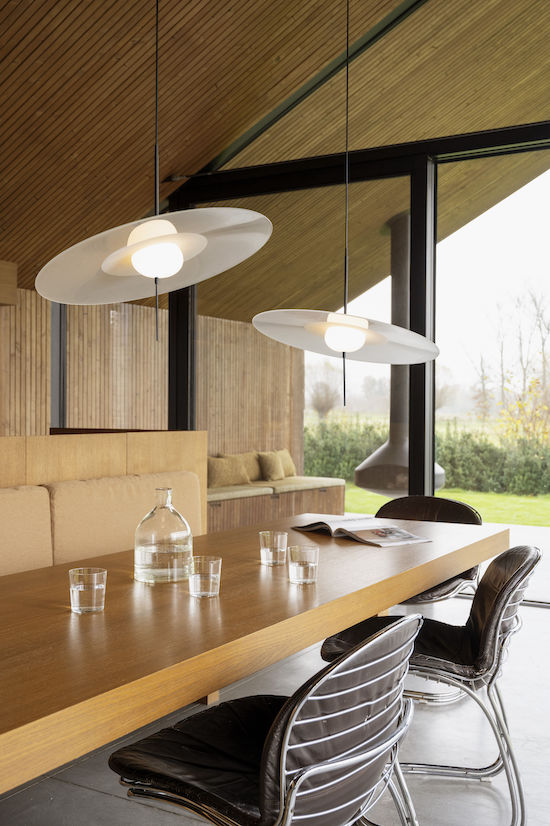 DCW Editions Mono pendant over long wooden dining table with a wooden sloped ceiling