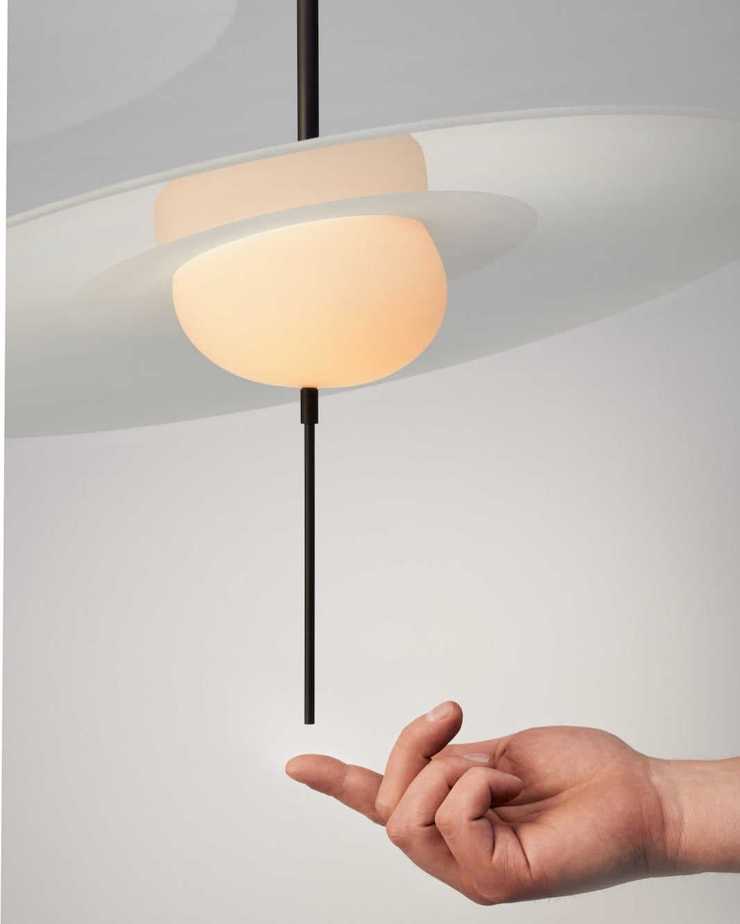 DCW Editions Mono pendant with person touching the dimming stem