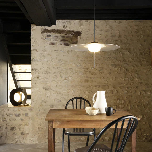 DCW Editions Mono pendant over small square table with stone wall