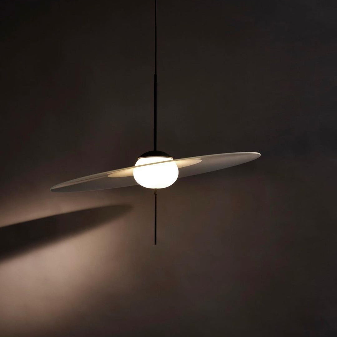 DCW Editions Mono pendant with glass disc at a slant with dark wall