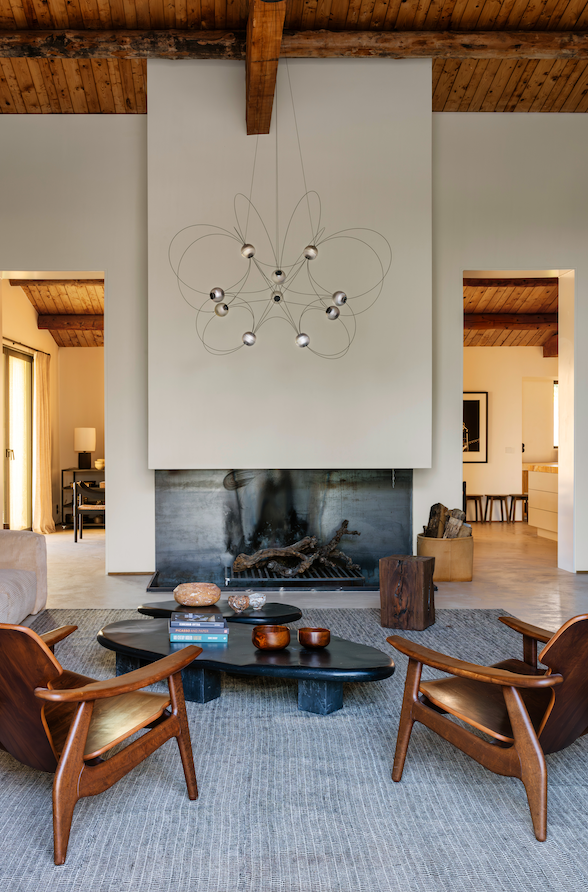 DCW Editions Munari pendant with 10 acrylic spheres and curved rods in lounge with wooden ceiling and fireplace