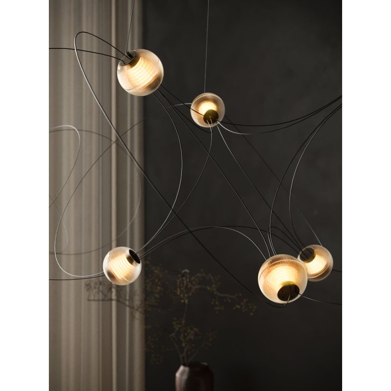 DCW Editions Munari pendant with acrylic spheres and curved rods warmly lit by window with curtain and vase