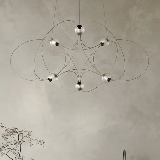 DCW Editions Munari pendant with 6 acrylic spheres and gold curved rods unlit on beige background