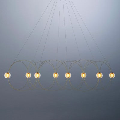 DCW Editions Munari pendant with gold, curved rods and 8 acrylic spheres with warm light on blue background