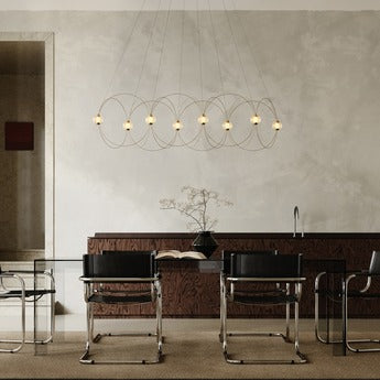 DCW Editions Munari pendant with 8 illuminated acrylic spheres and curved rods over glass conference desk with black chairs