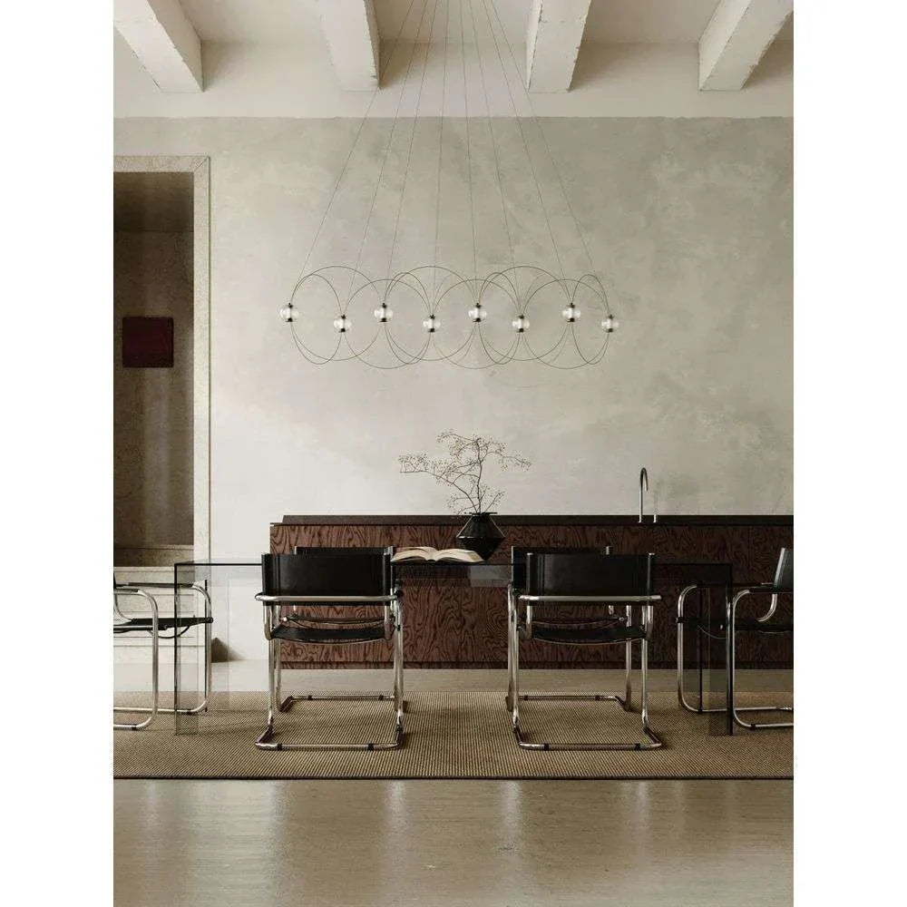 DCW Editions Munari pendant with 8 acrylic spheres and curved rods over glass conference desk with black chairs