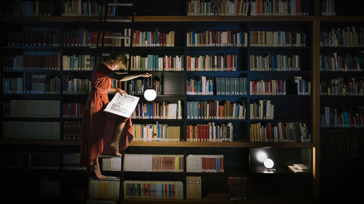 Nihm-Table-Lamp-In-Situ-with-Woman-In-Library