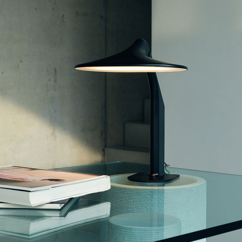 DCW Editions Niwaki black desk light on glass table with books