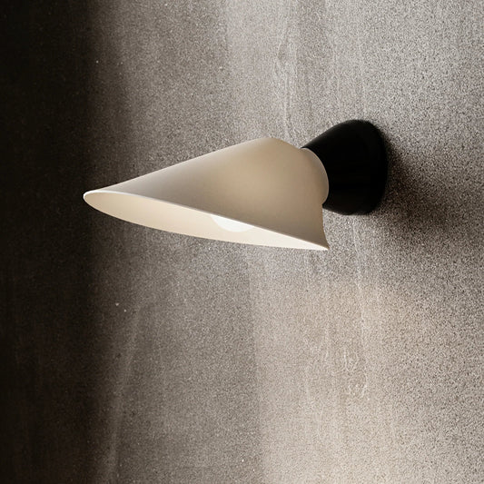 DCW Editions Plume wall light with porcelain shade and black base on grey concrete wall
