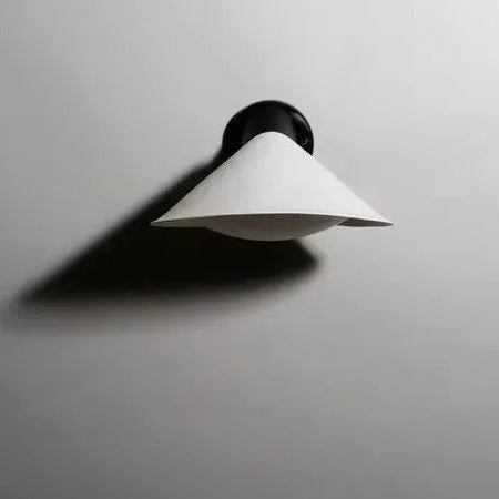 DCW Editions Plume wall light with diffuser and black base, unlit on white wall with shadow