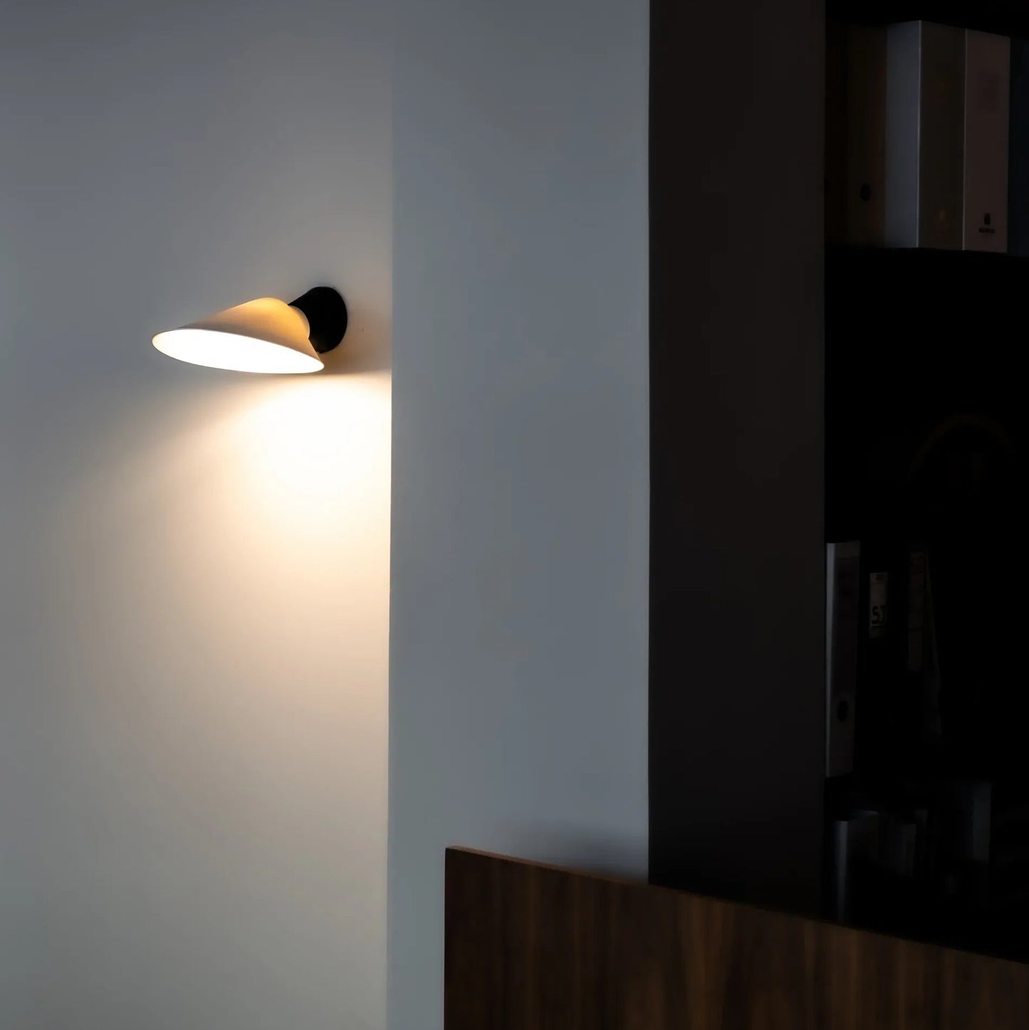 DCW Editions Plume wall light with porcelain shade on wall with unlit room to the side