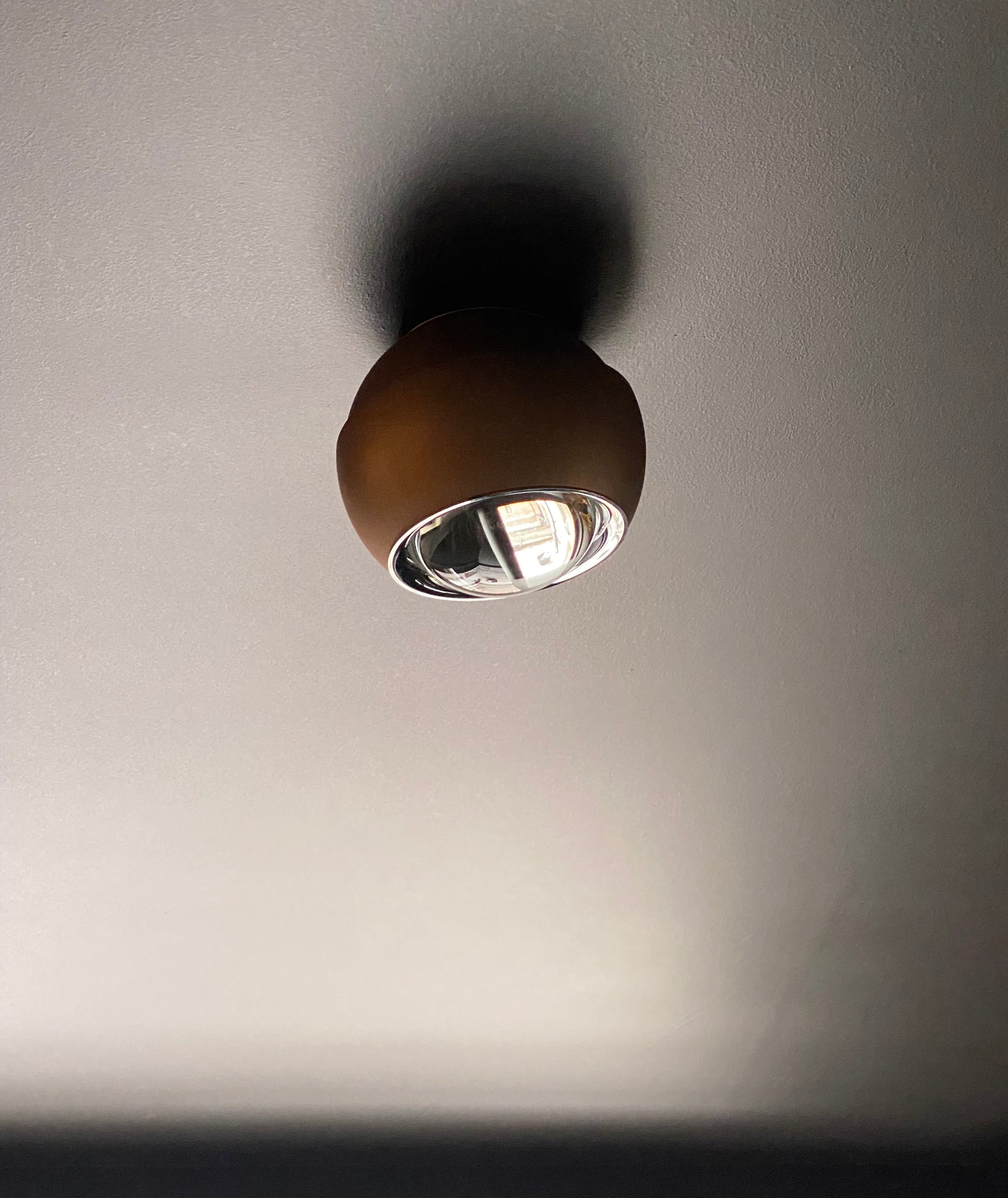 Bronze spot light on dark ceiling
