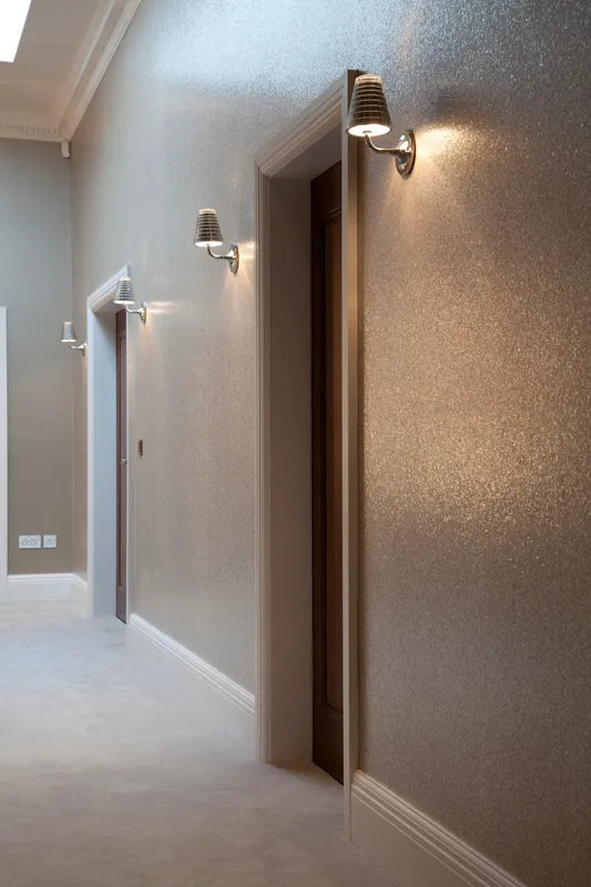 Small wall lights by doorways in hallway with dark, sparkly wall paper