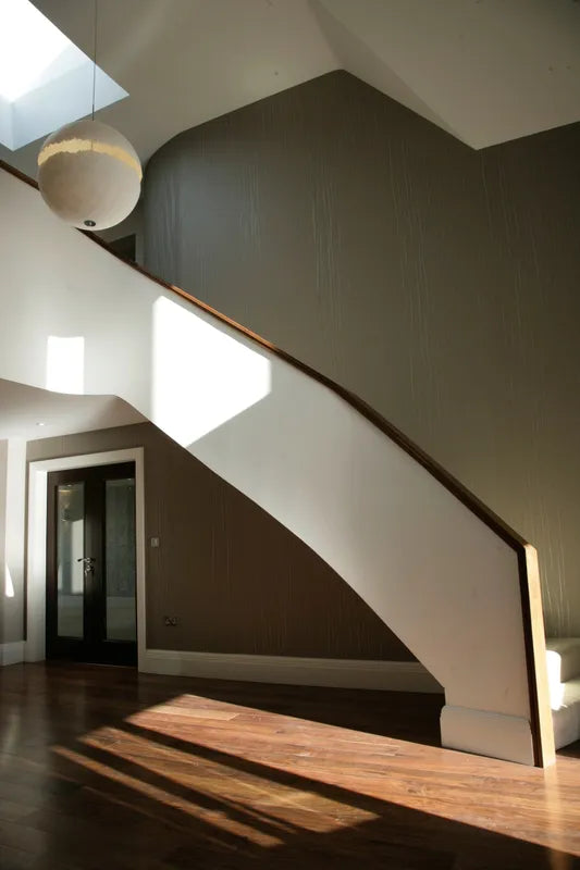 Sweeping staircase with Catalani and Smith pendant