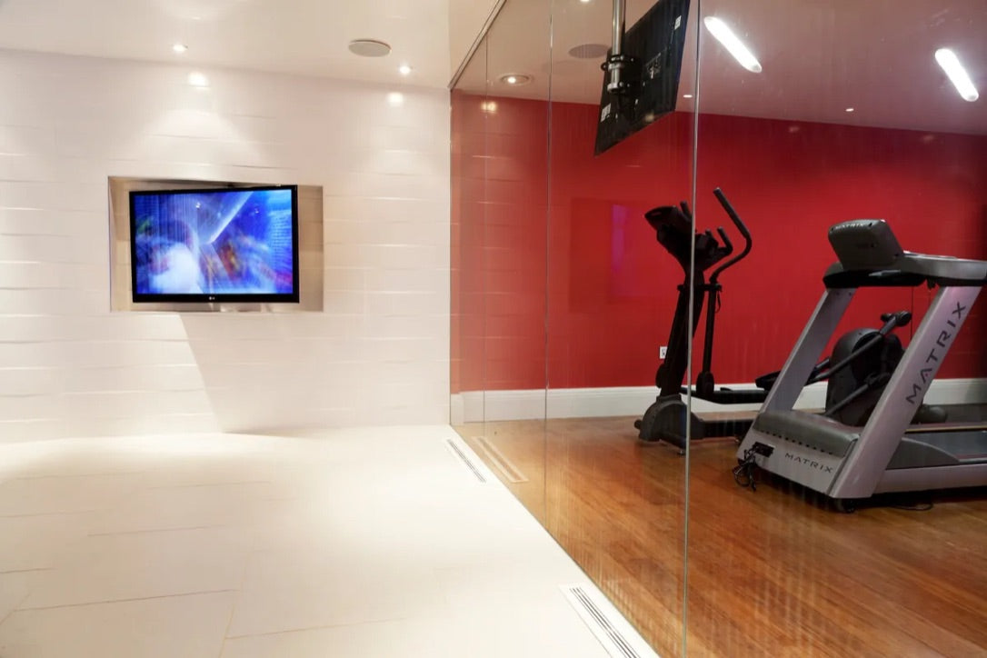 Recessed linear lights in home gym with red walls