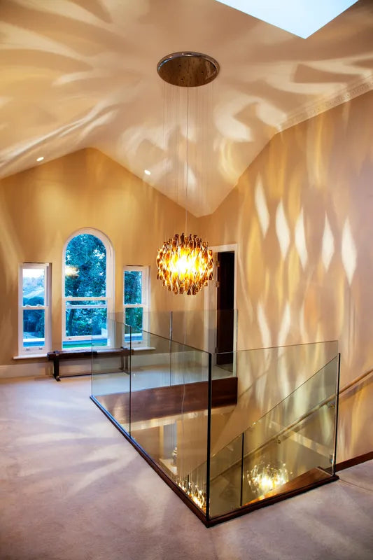 Amber glass chandelier casting wavy shadows in staircase