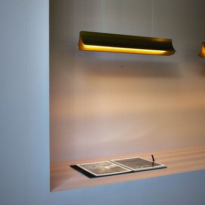 DCW Editions Respiro black and gold 900mm linear pendant over book close to wall