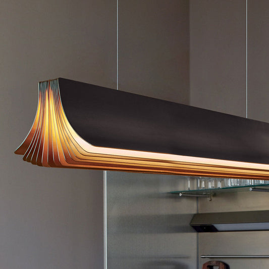 DCW Editions Respiro black and gold linear pendant illuminated in room with glass and brown walls close up