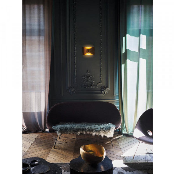 DCW Editions Respiro brass wall light in lounge with dark green walls, long curtains and purple furniture