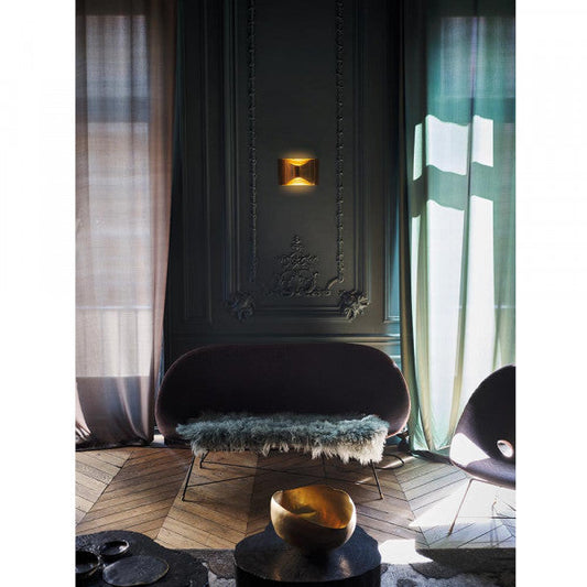 DCW Editions Respiro brass wall light in lounge with dark green walls, long curtains and purple furniture