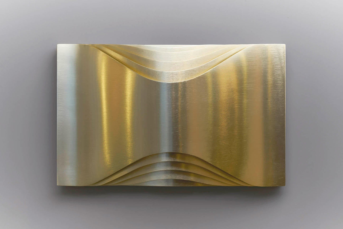 DCW Editions Respiro brass wall light with curved brass metal unlit on grey background