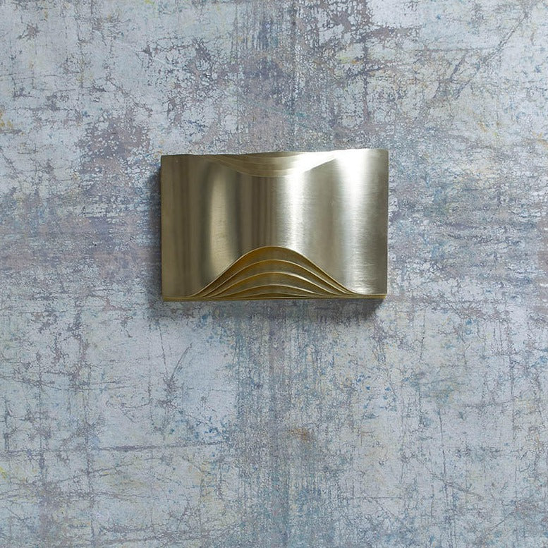 DCW Editions Respiro brass wall light with curved brass metal unlit on concrete wall
