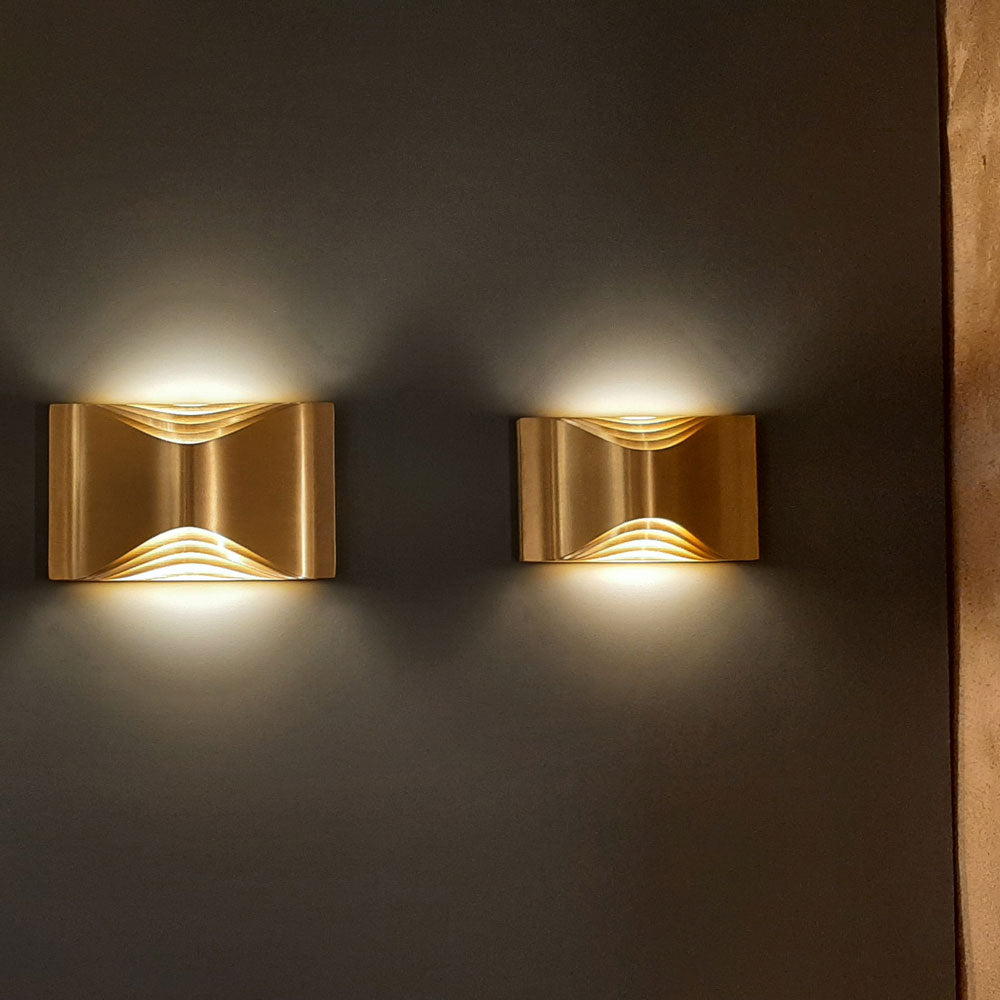 DCW Editions Respiro brass small and large wall lights illuminated on dark wall