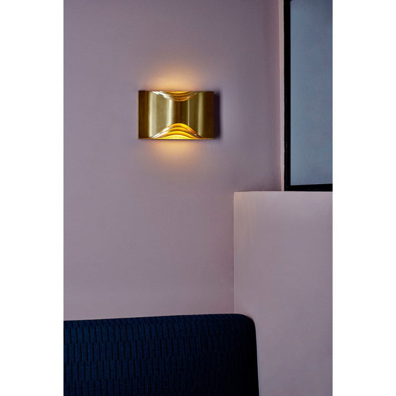 DCW Editions Respiro brass wall light lit on purple wall