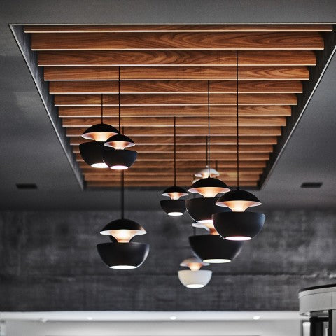 Modern pendant lights hanging from a wooden ceiling panel