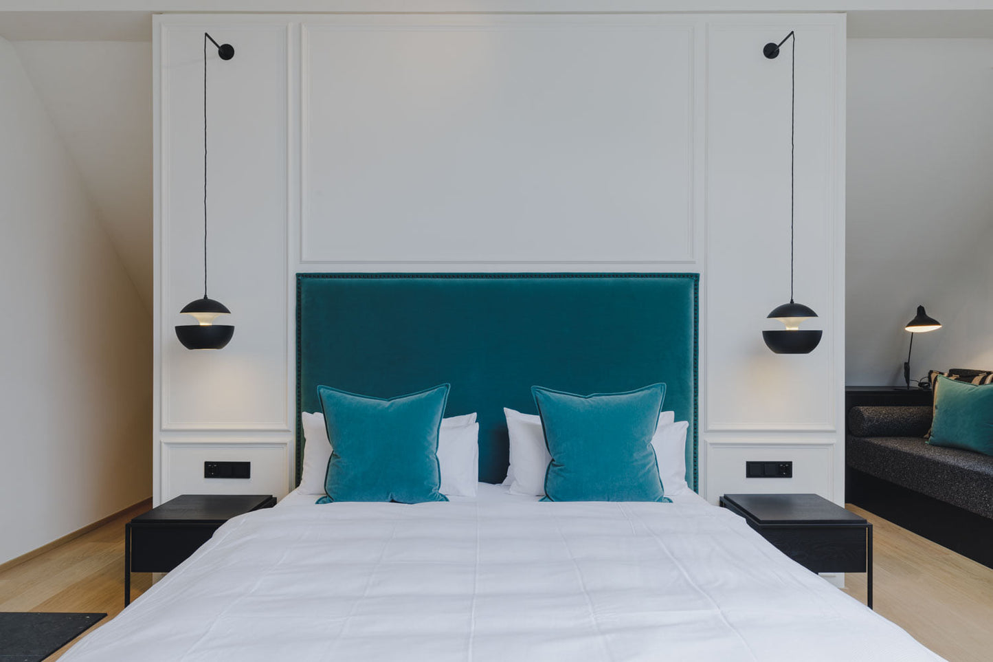 DCW Editions black Sun pendants by the bed and a Mantis table lamp in the corner