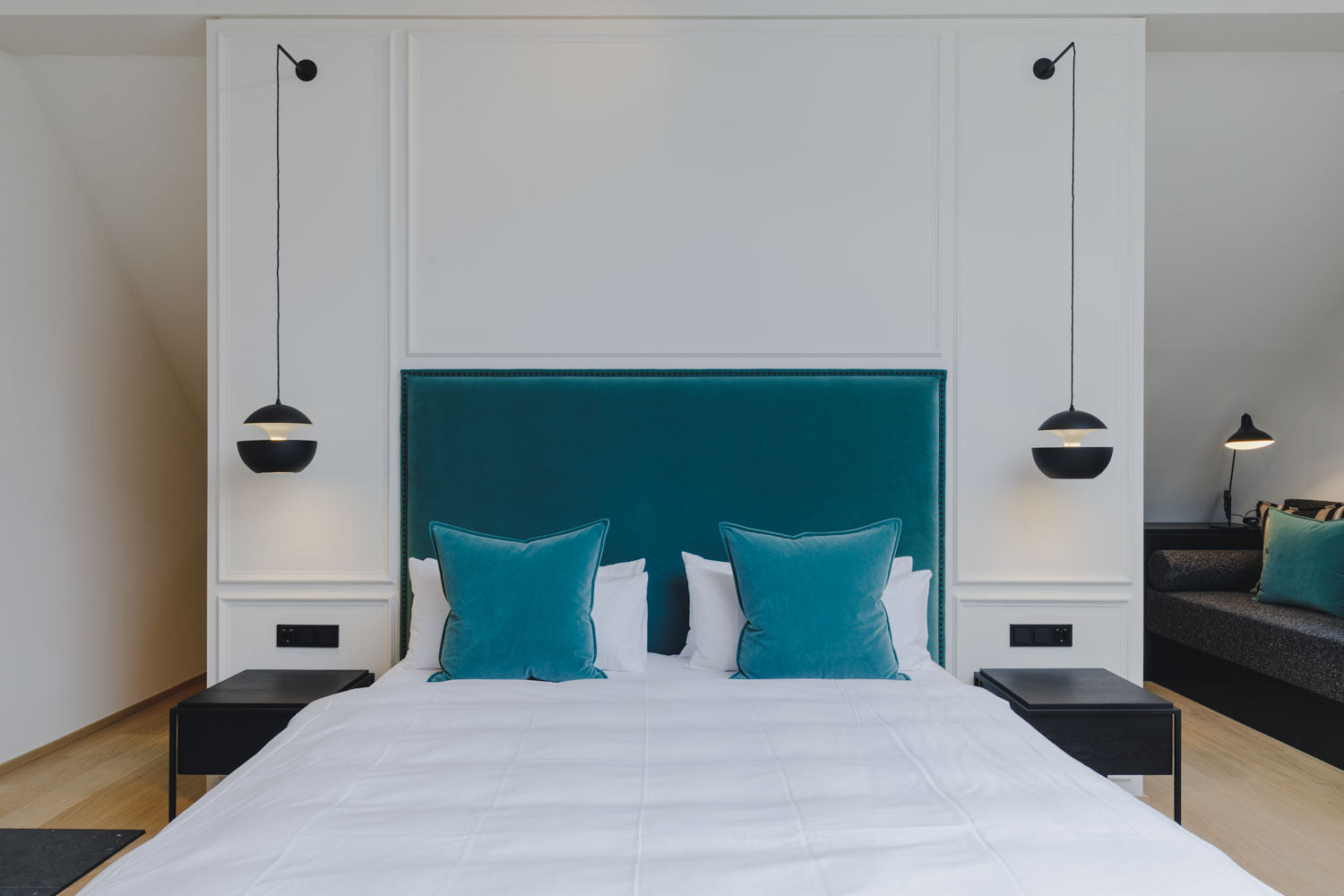 DCW Editions black Sun pendants by the bed and a Mantis table lamp in the corner
