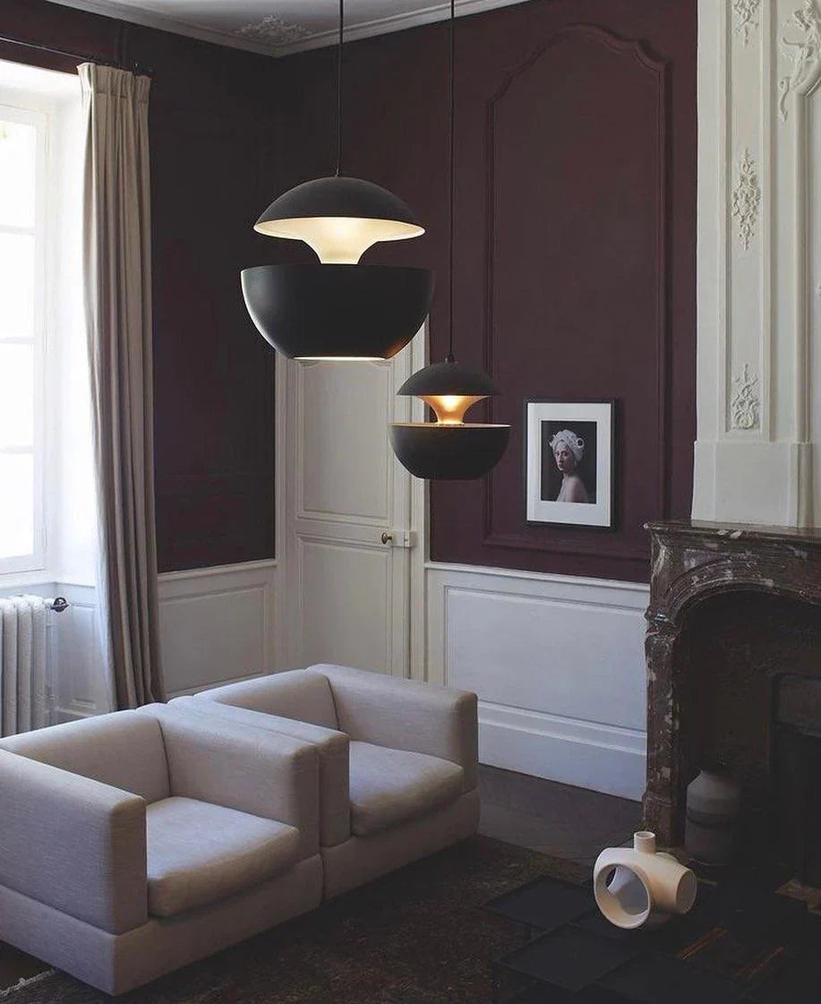 Modern living room with a white sofa, dark pendant lights, and a fireplace.