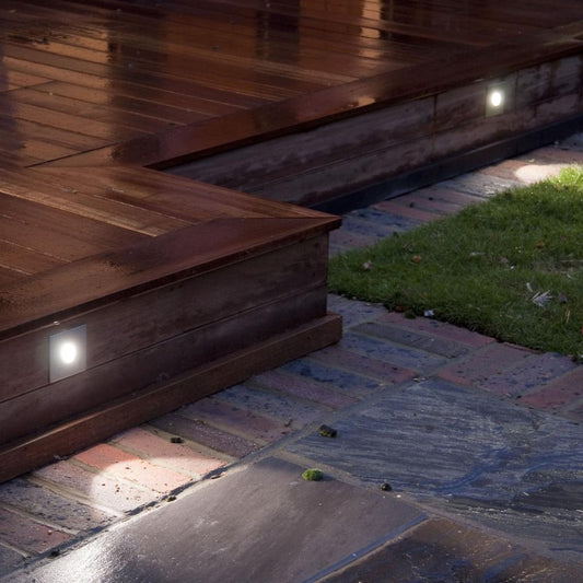 Astro Tango step light in brushed steel on wooden outdoor patio with single step