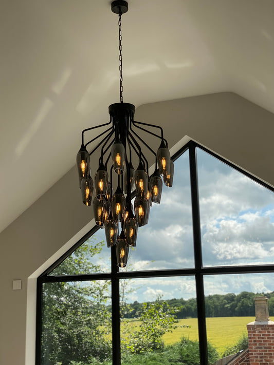 Softly lit chandelier in bedroom with vaulted ceilings and countryside views