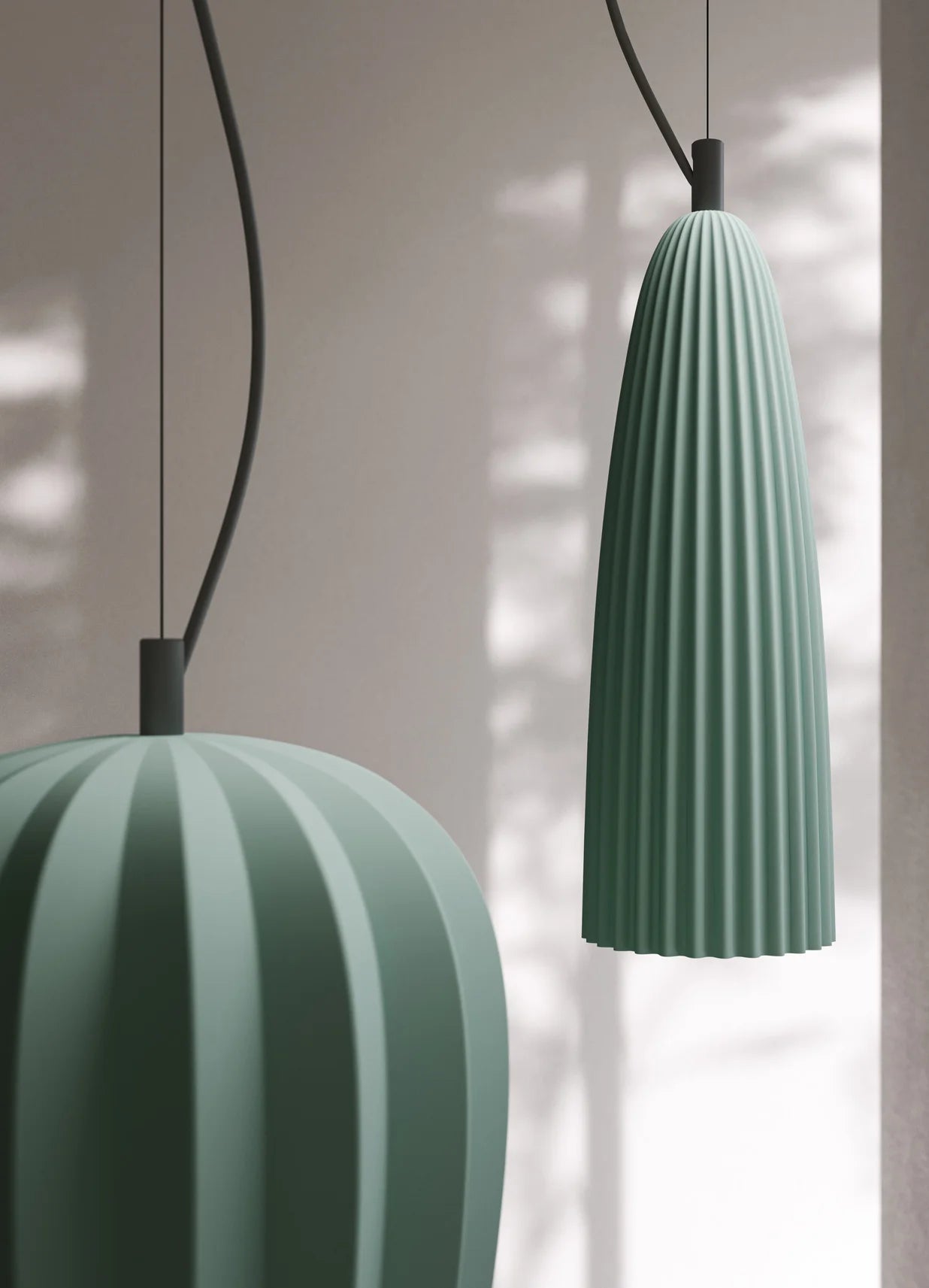 Two green pendant lights with ribbed ceramic design by Karman Italia hanging against a neutral background
