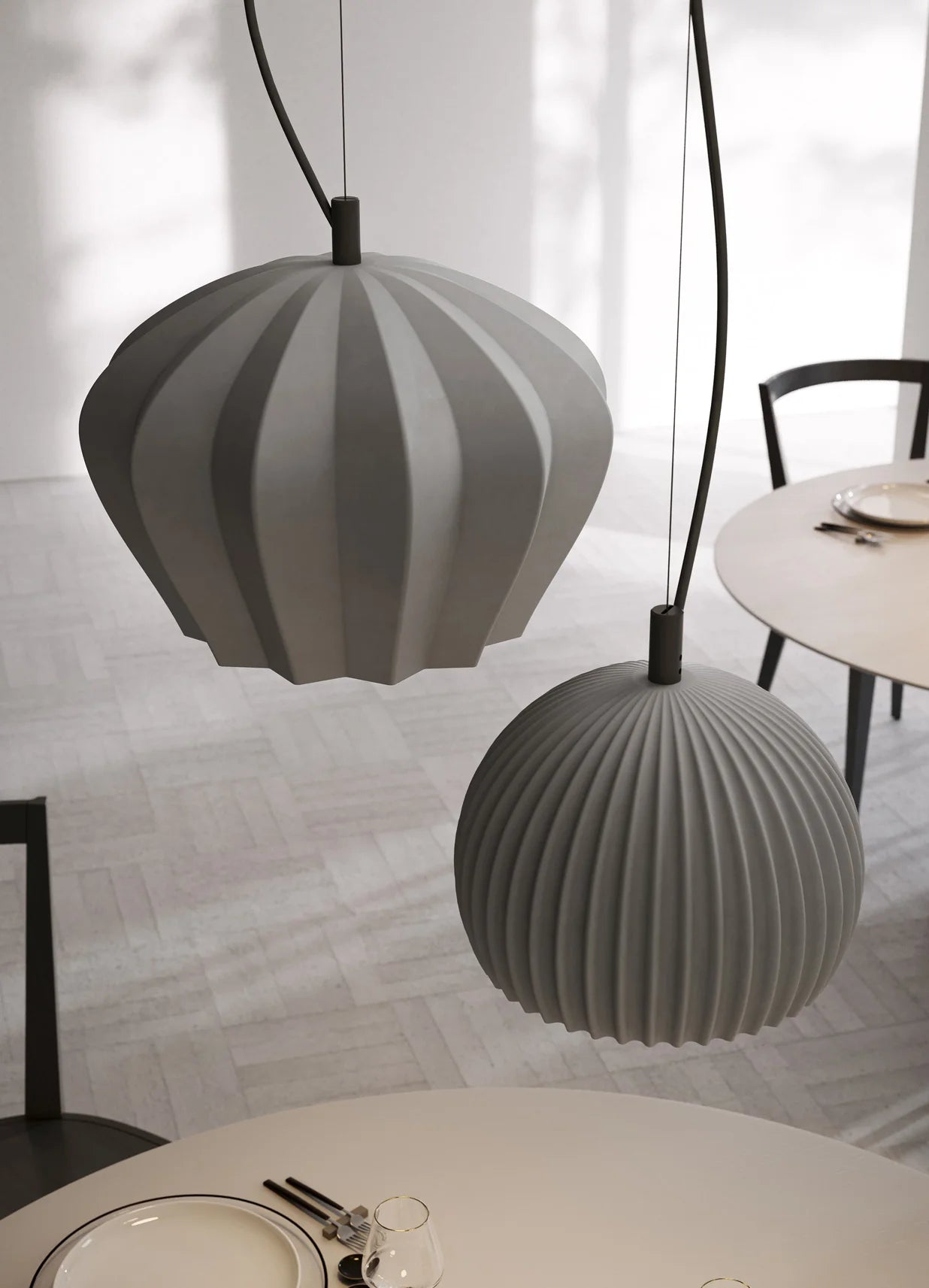 Modern grey ceramic Sahara pendant lights by Karman Italia hanging above a dining table with a neutral background