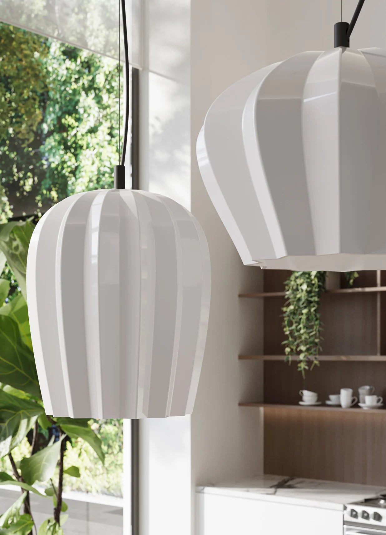 Two white ceramic, ribbed pendant lights by Karman Italia called Sahara, hanging in a modern kitchen with plants and shelves.